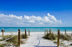 A beach with sand and grass on it