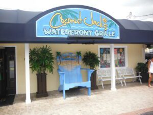 A blue chair sitting under a sign for the waterfront grille.