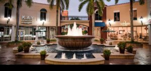 A fountain in the middle of a courtyard with palm trees.