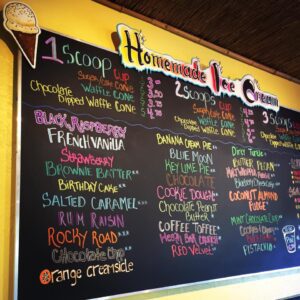 A chalkboard menu with various types of ice cream.