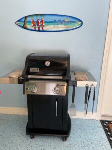 A black grill with two burners and one side shelf.