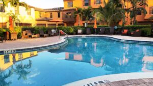 A pool with an orange building in the background.