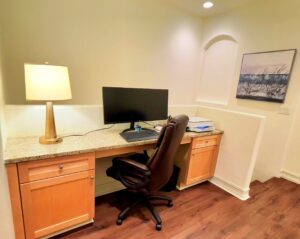 A desk with a computer and lamp on it