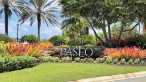 A sign that says paseo in front of some trees