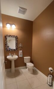 A bathroom with brown walls and white fixtures.