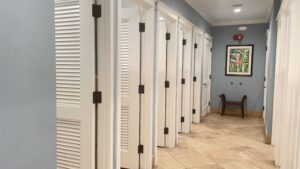 A row of white doors in a bathroom.