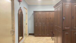 A room with two large wooden cabinets and a mirror.