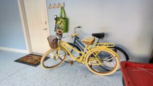 A yellow bike parked in front of a wall.