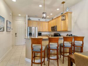 A kitchen with wooden cabinets and chairs in it