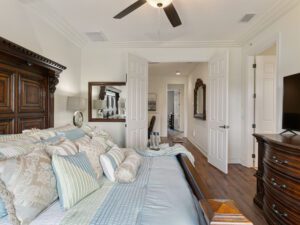 A bedroom with a bed, dresser and mirror.