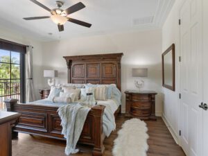 A bedroom with a bed, nightstand and ceiling fan.