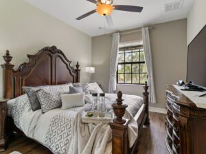 A bedroom with a bed, tray and window.