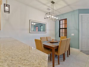 A dining room table with chairs and a mirror