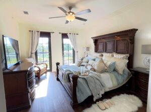 A bedroom with a bed, dresser and window.