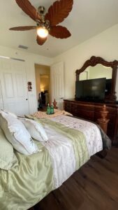 A view of the room with a fan with a light and a tv